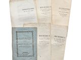 several old books sitting on top of each other on top of a table