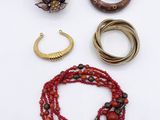 many different bracelets and rings on a white surface
