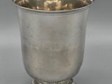 a silver cup on a pedestal on a gray background
