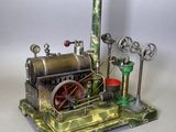 une petite maquette de machine à vapeur posée sur une table