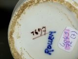 a close up of a vase with a tag on it