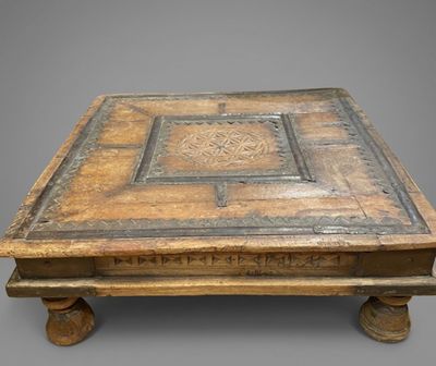 an old wooden coffee table with a decorative design on the top of it