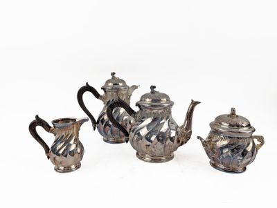 four pieces of silver tea and coffee set on a white surface