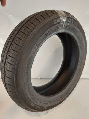 a close up of a tire on a white surface with a hand holding it