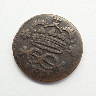 une vieille pièce de monnaie surmontée d'une couronne, posée sur un fond blanc