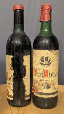 two bottles of wine sitting on top of a wooden table next to each other