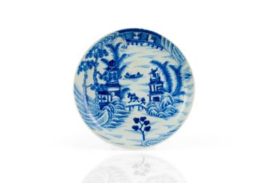 une assiette bleue et blanche avec un paysage dessus