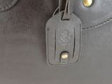 a close up of a black purse with a tag on it