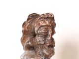 sculpture représentant une tête d'homme sur un rocher, sur un fond blanc
