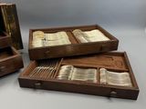 trois plateaux en bois contenant des couverts, posés sur une table