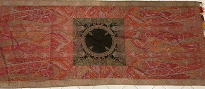 un grand tapis rouge et orange sur lequel figure un oiseau noir