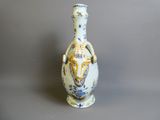 un vase blanc orné d'un motif bleu et jaune