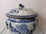 a blue and white bowl with a lid on a glass shelf