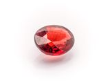 a close up of a red garnet stone on a white background