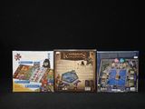 four board games are lined up on a black surface