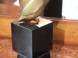 a statue of a bird sitting on top of a black box