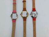 three different watches sitting on top of each other on a table