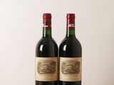 two bottles of wine sitting on a wooden table next to each other