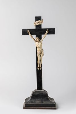 une statue de Jésus sur la croix, posée sur un socle