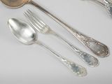 four silver spoons and two silver spoons on a table
