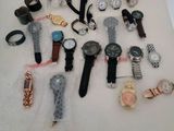 many different types of watches displayed on a table
