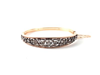 un gros plan sur un bracelet jonc en or serti de diamants noirs et blancs