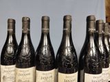 several bottles of red wine are lined up on a table