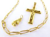a close up of a gold necklace with a cross and a bell