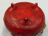 a red pomegranate sitting on a plate on a table