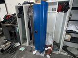a blue locker in a room with a lot of clutter