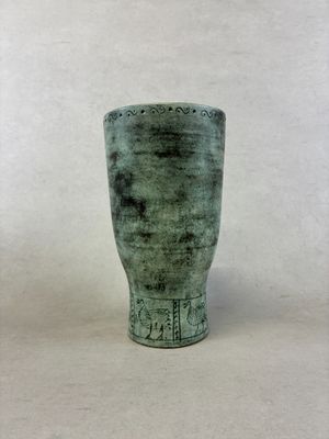 un vase vert posé sur une table