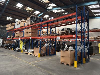 L'entrepôt est rempli de cartons empilés sur les rayonnages.