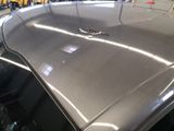 a close up of the hood of a car in a showroom