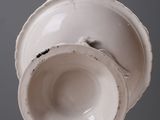 a white cup sitting on top of a white table