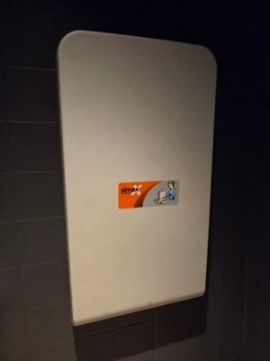a white toilet with a sticker on it in a bathroom