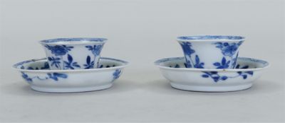 une paire de tasses et soucoupes bleues et blanches posées sur un fond blanc