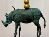 statue d'un rhinocéros avec une corne dorée au sommet de la tête