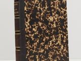 a brown and black book sitting on top of a white table