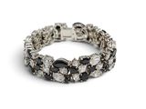 un gros plan sur un bracelet orné de pierres noires et blanches