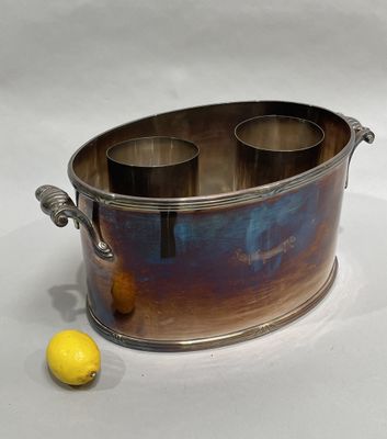 a metal container with three cups in it and a lemon on the table