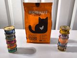 trois boîtes de nourriture pour chat et un sac de nourriture pour chat posés sur une table