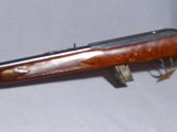 an old gun with a green case on a white surface