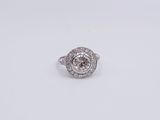 a close up of a diamond ring on a white surface
