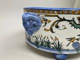 a blue and white planter with birds and flowers on it