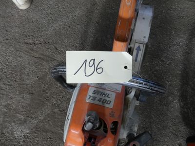 a sign on the handle of a chainsaw on the ground