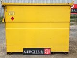 the yellow dumpster is parked in front of a building