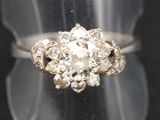 une photo en gros plan d'une bague en diamant posée sur un présentoir transparent