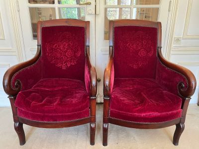 two red chairs sitting next to each other in a room