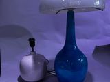 une lampe de table en verre bleu surmontée d'un dôme blanc