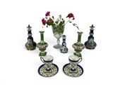 many different vases and saucers with flowers in them